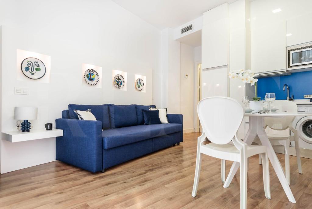a living room with a blue couch and a table at Central apartment by Picasso Museum by REMS in Málaga