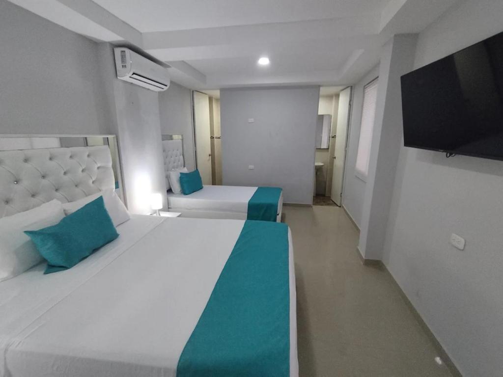 a bedroom with two beds and a flat screen tv at Bm-7 room near the sea with air conditioning and WIFI in Cartagena de Indias