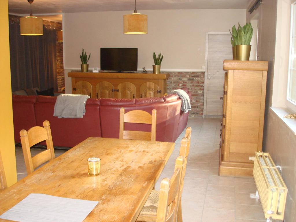 a dining room with a wooden table and chairs at appartement Courcelles in Courcelles