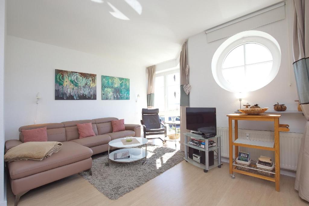 a living room with a couch and a tv at Dünenblick Wohnung 07 in Boltenhagen