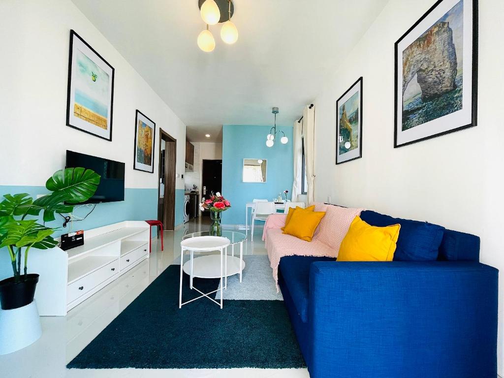 sala de estar con sofá azul y mesa en Sea&CityView 2-bedroom Fully Furnished Apartment Forest City #freeWIFI, en Gelang Patah