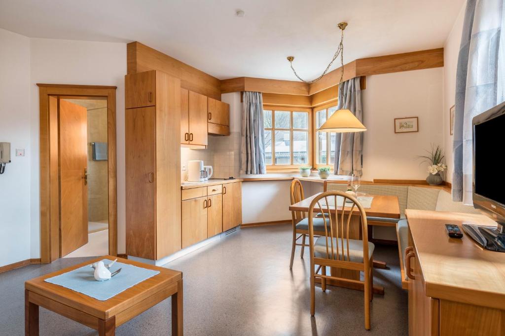 eine Küche und ein Wohnzimmer mit einem Tisch und einem Esszimmer in der Unterkunft Taufner Apartement C 103 in Partschins