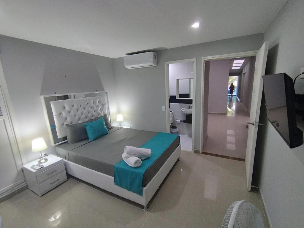a bedroom with a large bed with blue pillows at Bm-9 room near the sea with air conditioning and WIFI in Cartagena de Indias