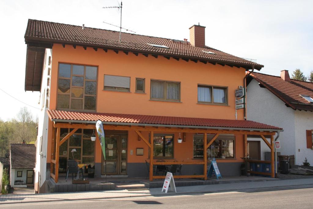 ein orangefarbenes Gebäude mit einem Schild davor in der Unterkunft Hotel Michaela in Ramstein-Miesenbach