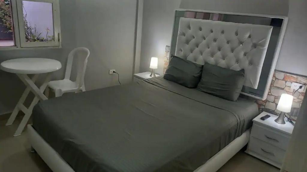 a bedroom with a bed and a table and a chair at Bm-4 room near the sea with air conditioning and WIFI in Cartagena de Indias