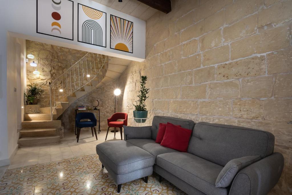 un soggiorno con divano e muro di mattoni di Authentic Maltese 2-bedroom House with Terrace a Żejtun