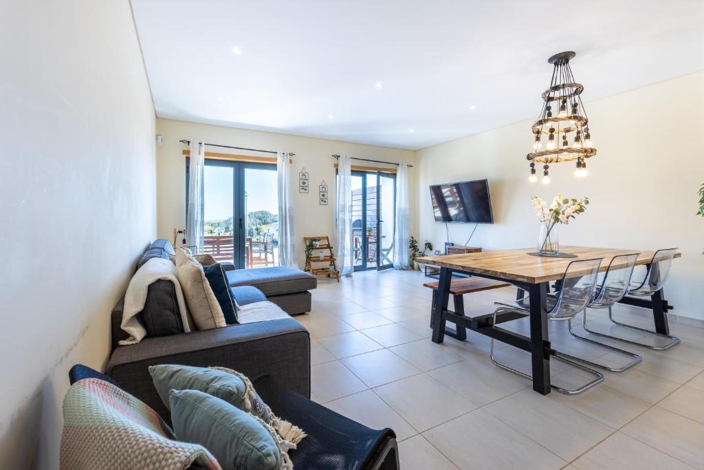 a living room with a couch and a table at Margarida Sun House Ocean View in Raposeira