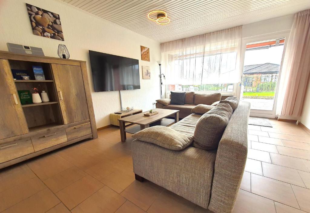 sala de estar con sofá y TV en Villa Strandgut, en Wangerland