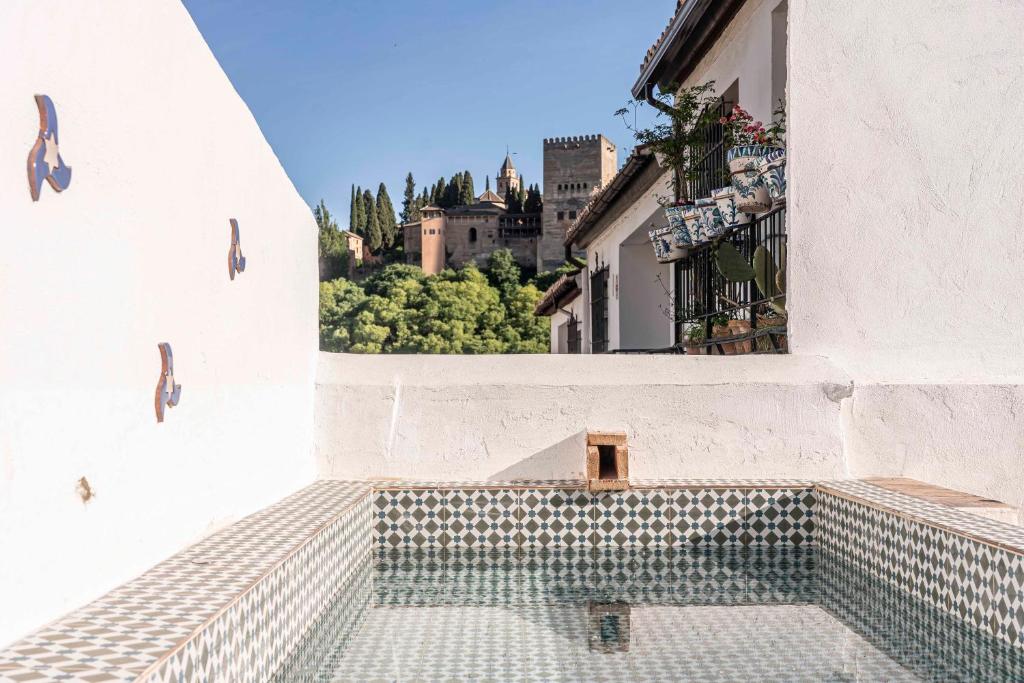 a swimming pool in the side of a building with a window at Carmen de Cortes in Granada