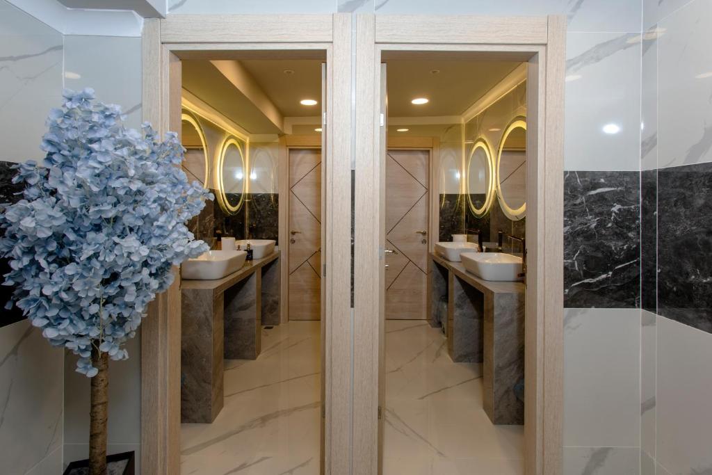 a bathroom with two sinks and two mirrors at Lahza Apart Hotel in Trabzon