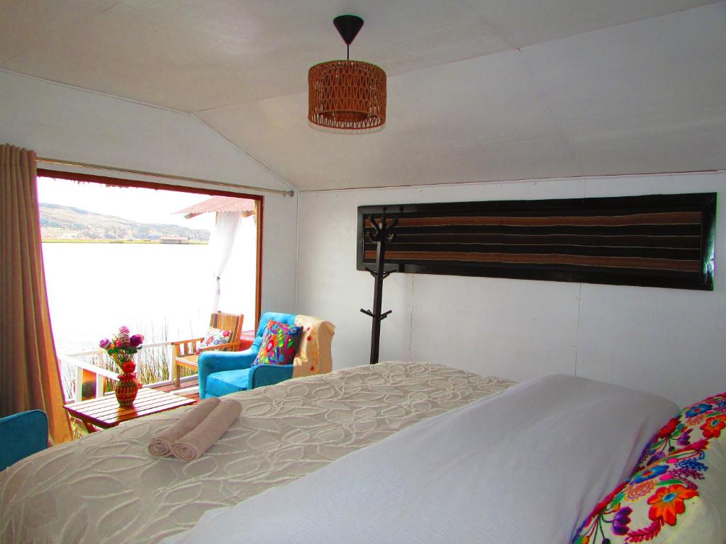 1 dormitorio con cama y vistas a un balcón en Titicaca tikary's lodge en Puno