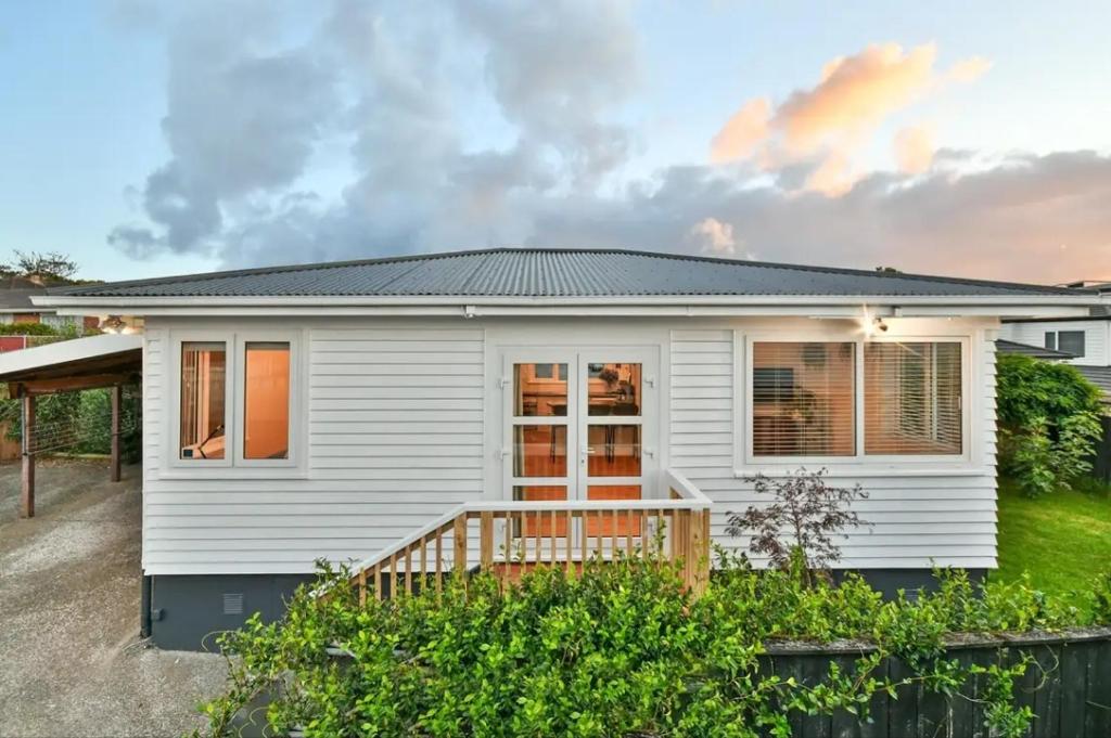 a white tiny house with a porch at Cute and Cozy near Airport in Auckland