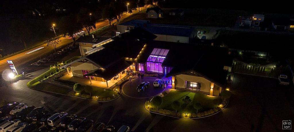 un edificio con una luz púrpura en él por la noche en U Ojdanów, en Węgrów