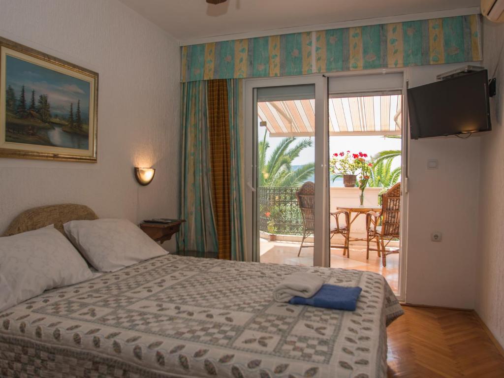 a bedroom with a bed and a view of a patio at Apartments Dikan in Herceg-Novi
