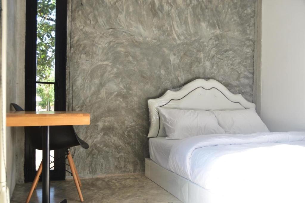 a bedroom with a bed and a desk and a wall at My Destiny in Ban Wang Muang (1)