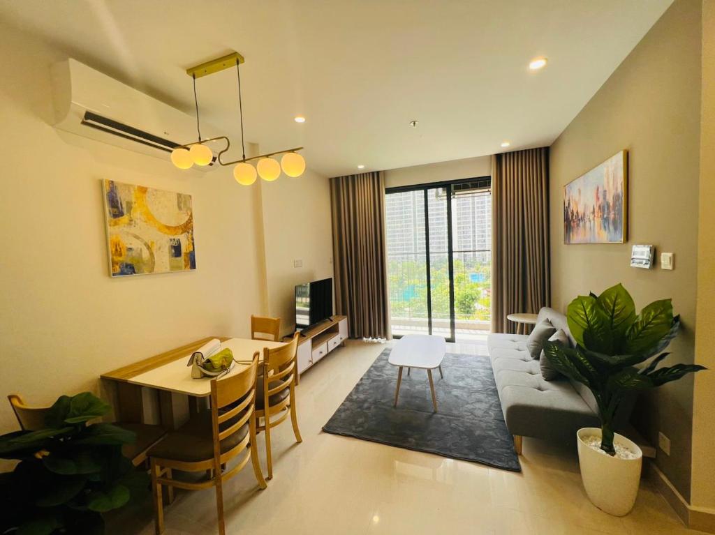 sala de estar con sofá y comedor en The Luxury Zen Origami Residence - Heart of Vinhomes Grand Park en Long Bình