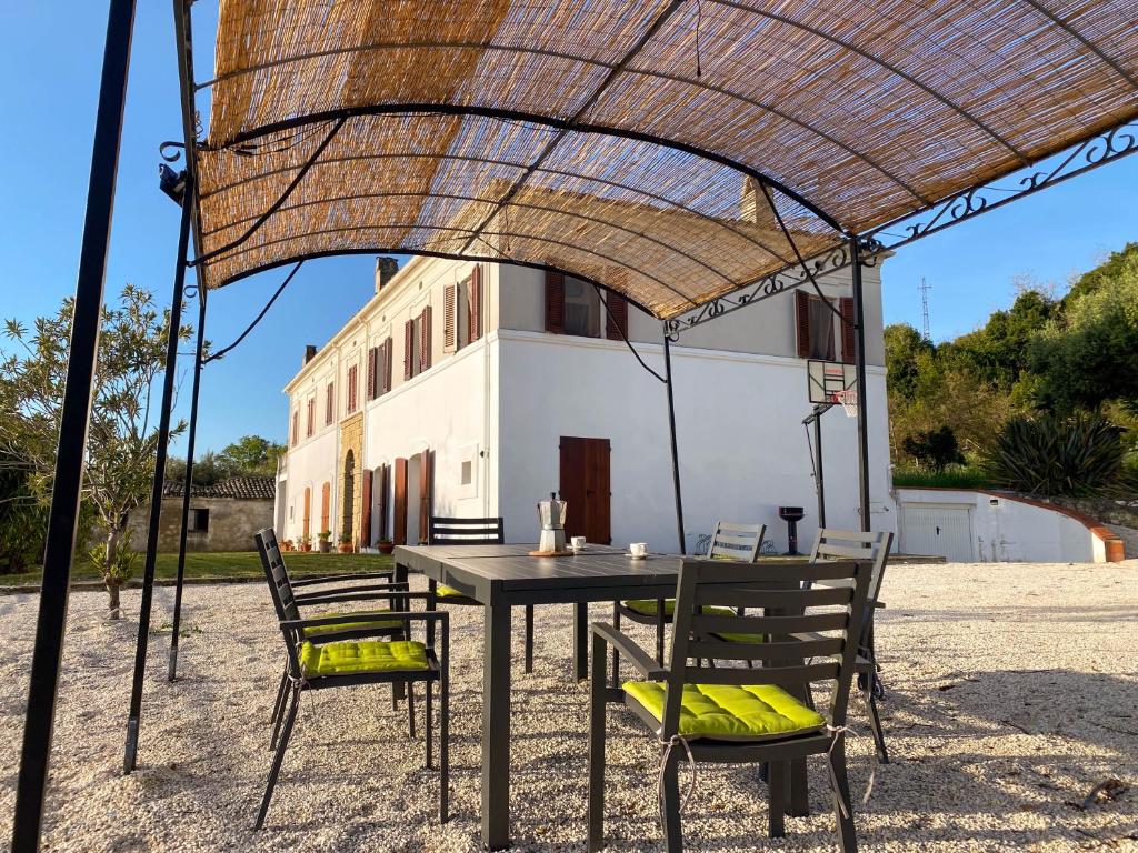 une table et des chaises sous un grand parasol dans l'établissement Villa dei Trabocchi - Accogliente casale per famiglie che affaccia sul mare, à Ortona
