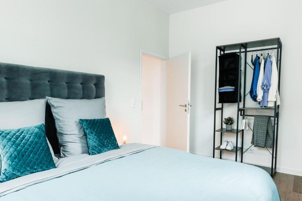 1 dormitorio con 1 cama grande con almohadas azules en Deluxe Flat, PS4, Parken, Netflix, Zentral en Offenbach