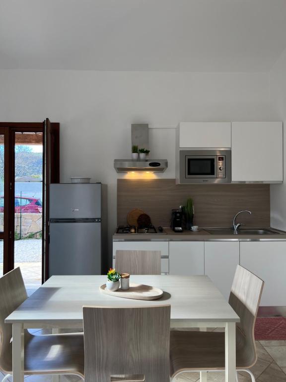 eine Küche mit einem Tisch und Stühlen in der Unterkunft Appartamento La Conchiglia a pochi passi dal centro in San Teodoro