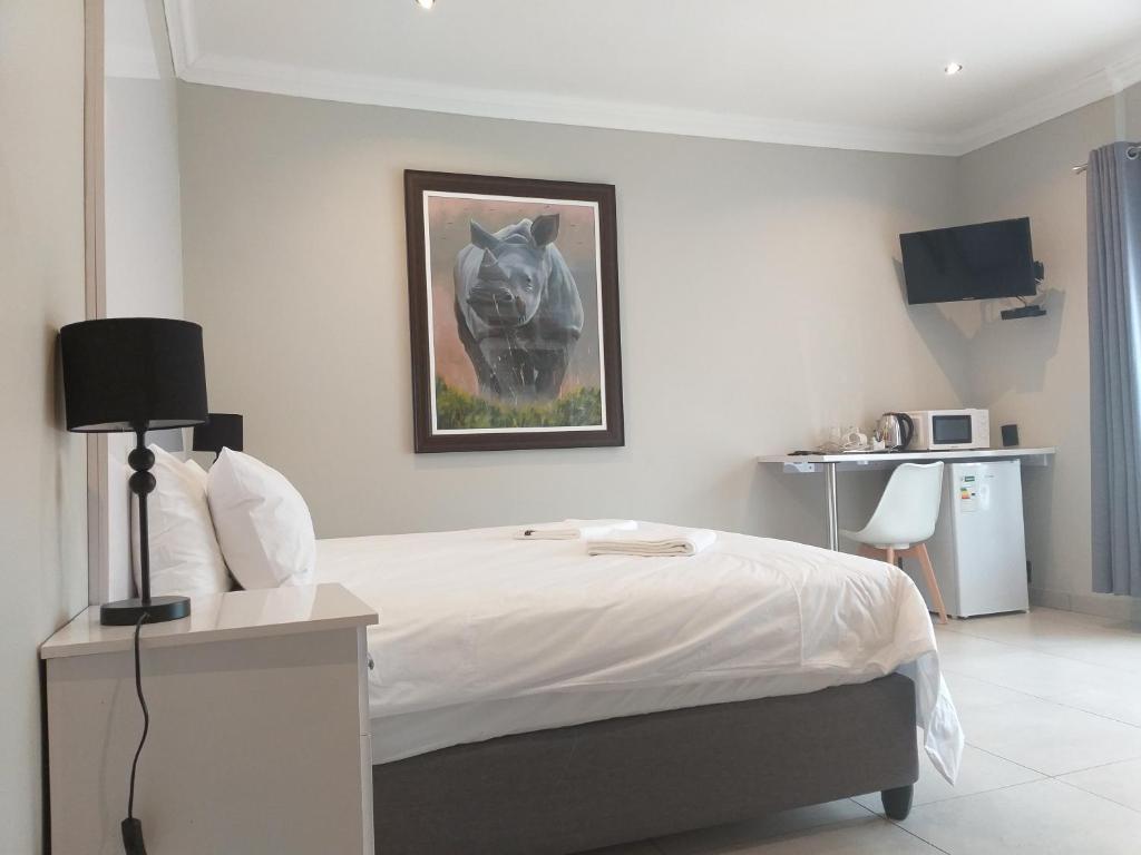 a bedroom with a bed with a picture of a horse on the wall at Kanyane @ Graskop in Graskop