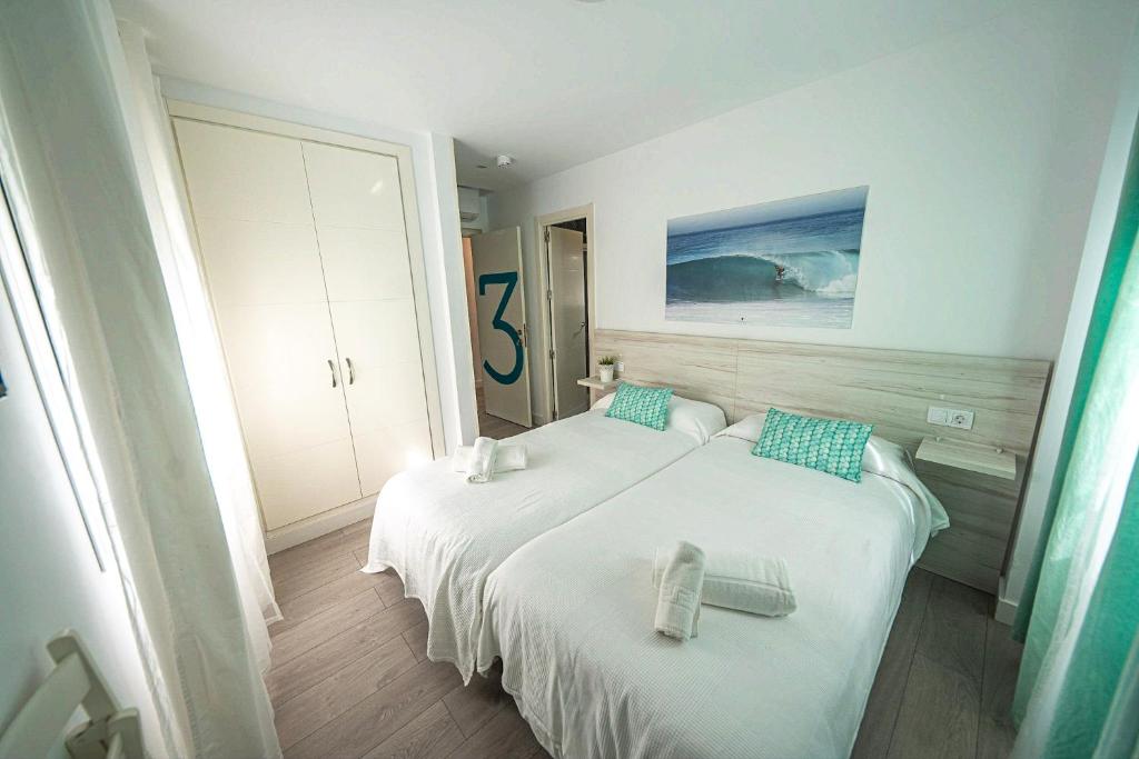 um quarto de hotel com duas camas e uma grande janela em L'Boutique Tarifa ROOMS em Tarifa