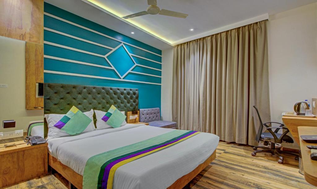 sypialnia z dużym łóżkiem z niebieską ścianą w obiekcie Treebo Trend Prince, Mumbai w Bombaju