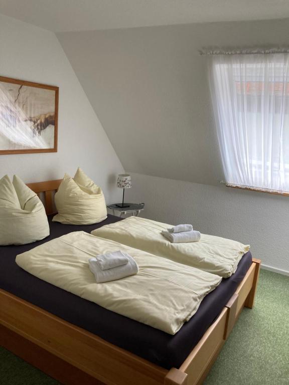 een slaapkamer met 2 bedden en handdoeken bij Ferienwohnung Kellerer 2 in Waischenfeld