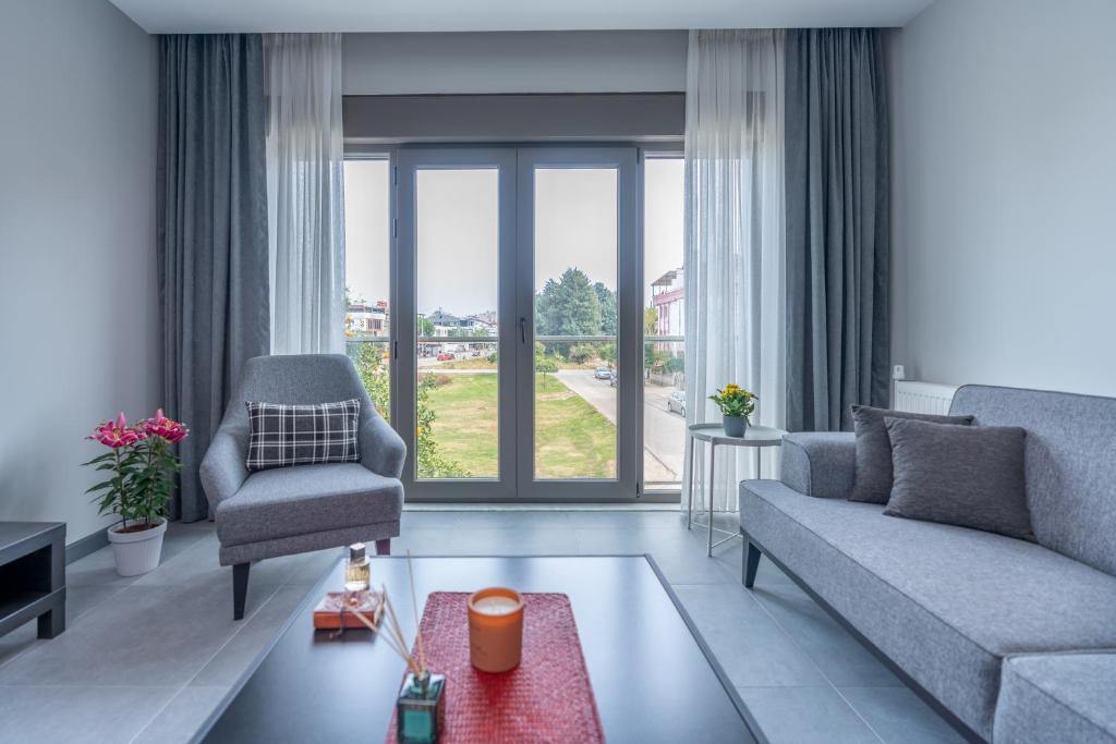 - un salon avec un canapé et une chaise dans l'établissement Rose Residence - Trendy Apartments Near The Beach, à Antalya