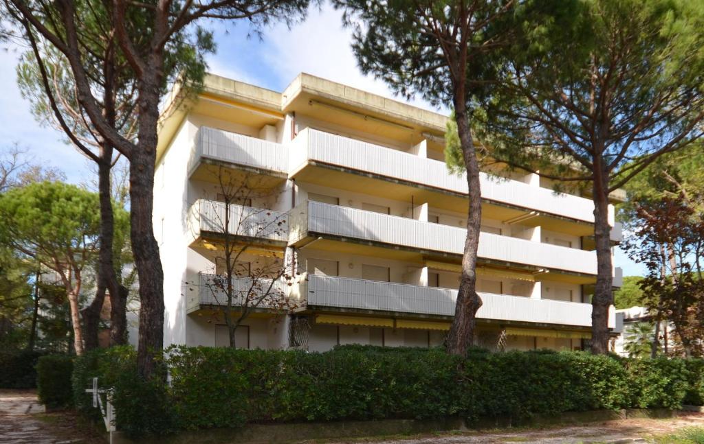un edificio con alberi di fronte di Appartamenti Verdemare a Lignano Sabbiadoro