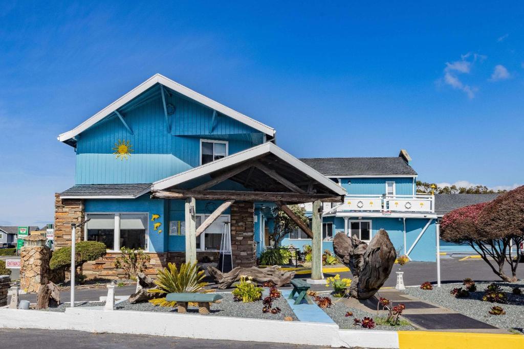 a blue house with a garden in front of it at Oceanside Inn & Suites, a Days Inn by Wyndham in Fort Bragg
