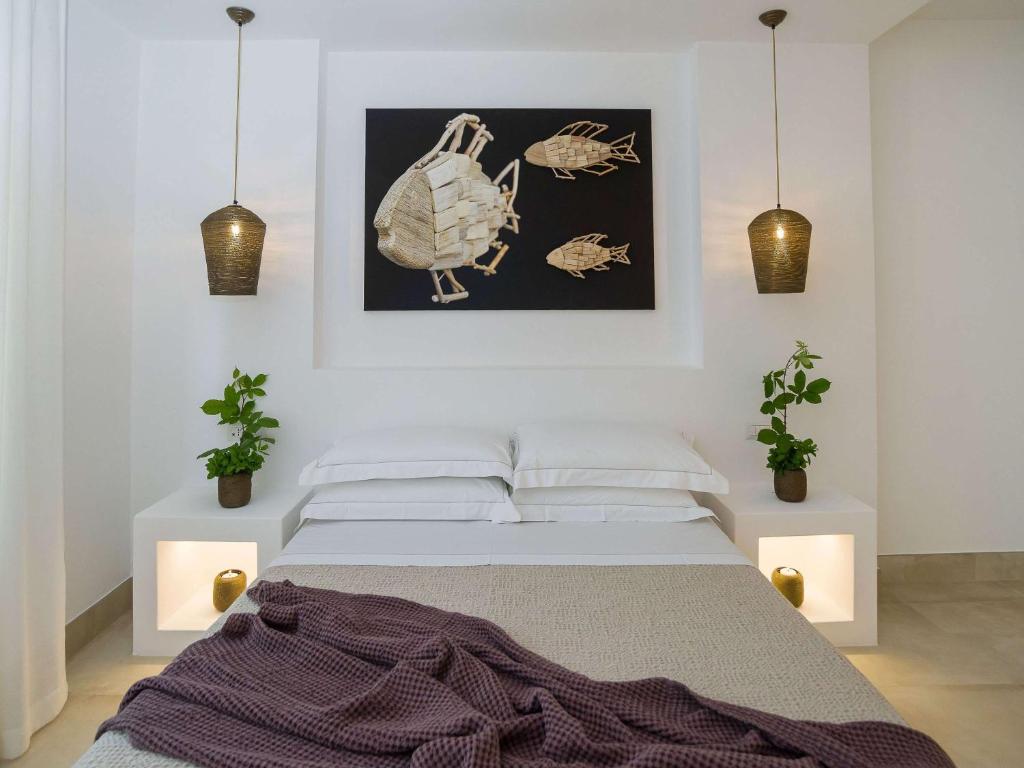 a bedroom with a bed and two potted plants at Hotel Baia Delle Zagare in Mattinata