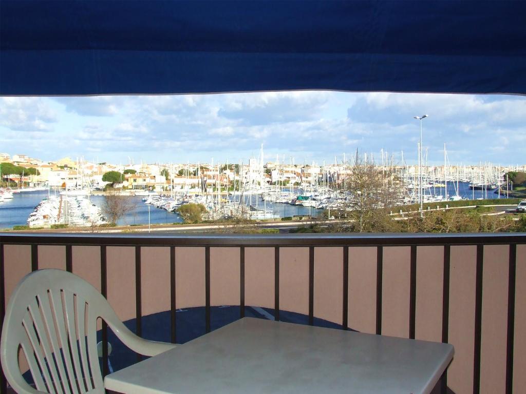 a white chair and a table on a balcony with a view at Hotel Alhambra in Cap d&#39;Agde