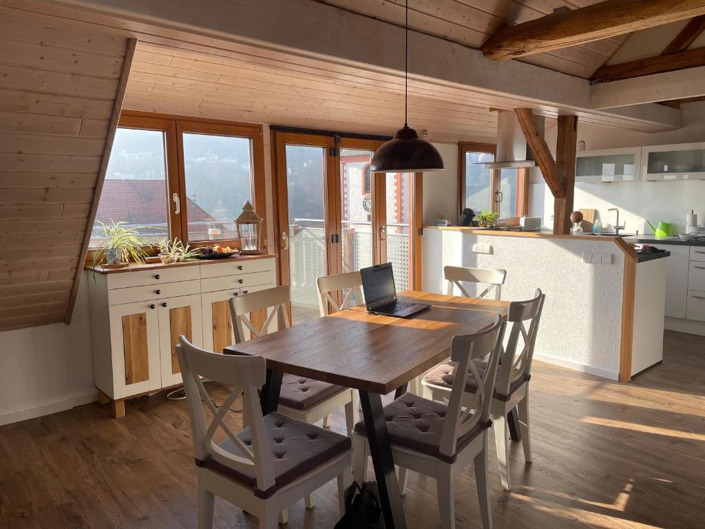 una cocina con mesa de madera y ordenador portátil. en Sonniges Ferienapartment am Alten Binauer Schloss, 