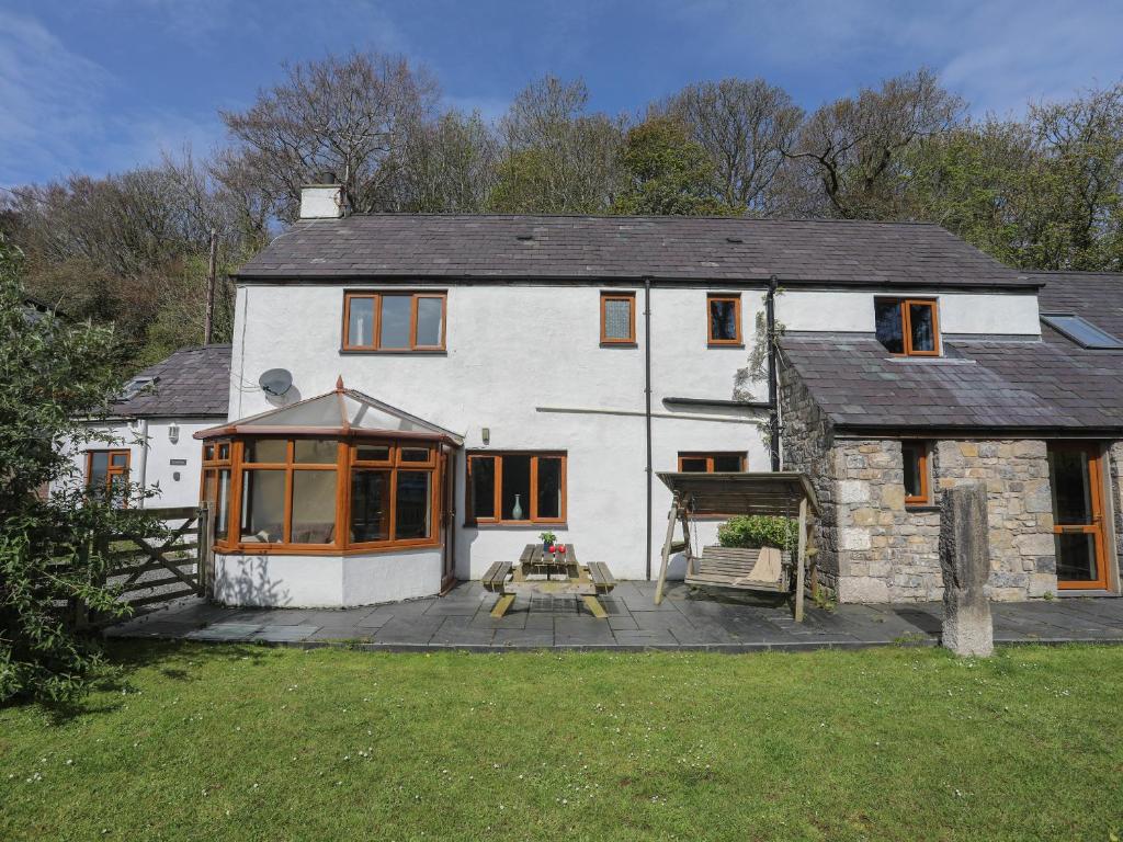 a large white house with a patio in front of it at Long House in Beaumaris