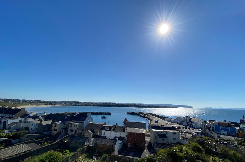 a view of a city with the sun in the sky at Harbour View Apartment at Royale Court Apartments Portrush in Portrush