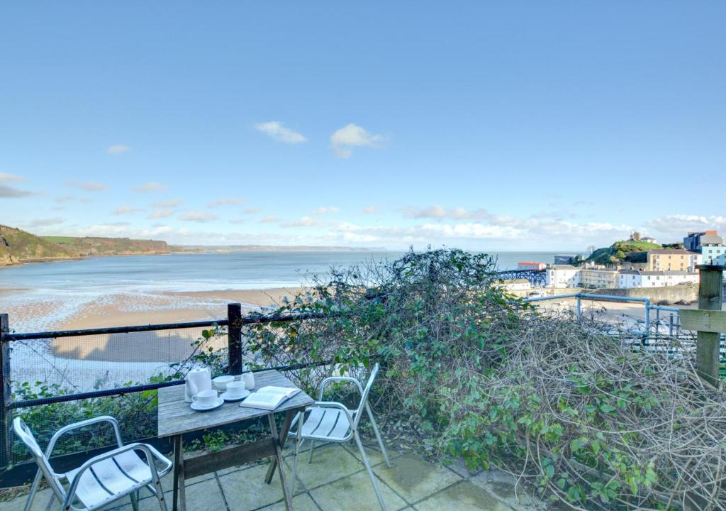 - Balcón con mesa y sillas y vistas a la playa en Harbwr Hafod y Mor, en Tenby
