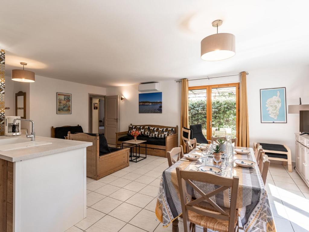 a kitchen and a living room with a dining table at Holiday Home Chez Béatrice et Pascal by Interhome in Belgodère