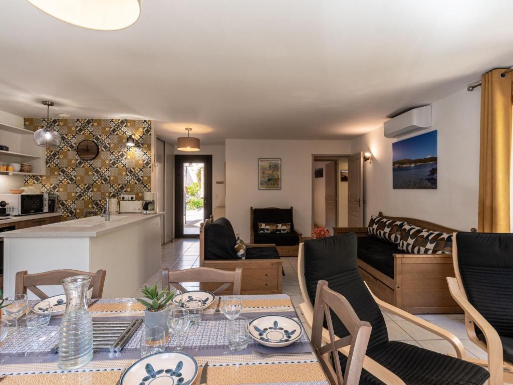 a kitchen and living room with a table and chairs at Holiday Home Chez Béatrice et Pascal by Interhome in Belgodère