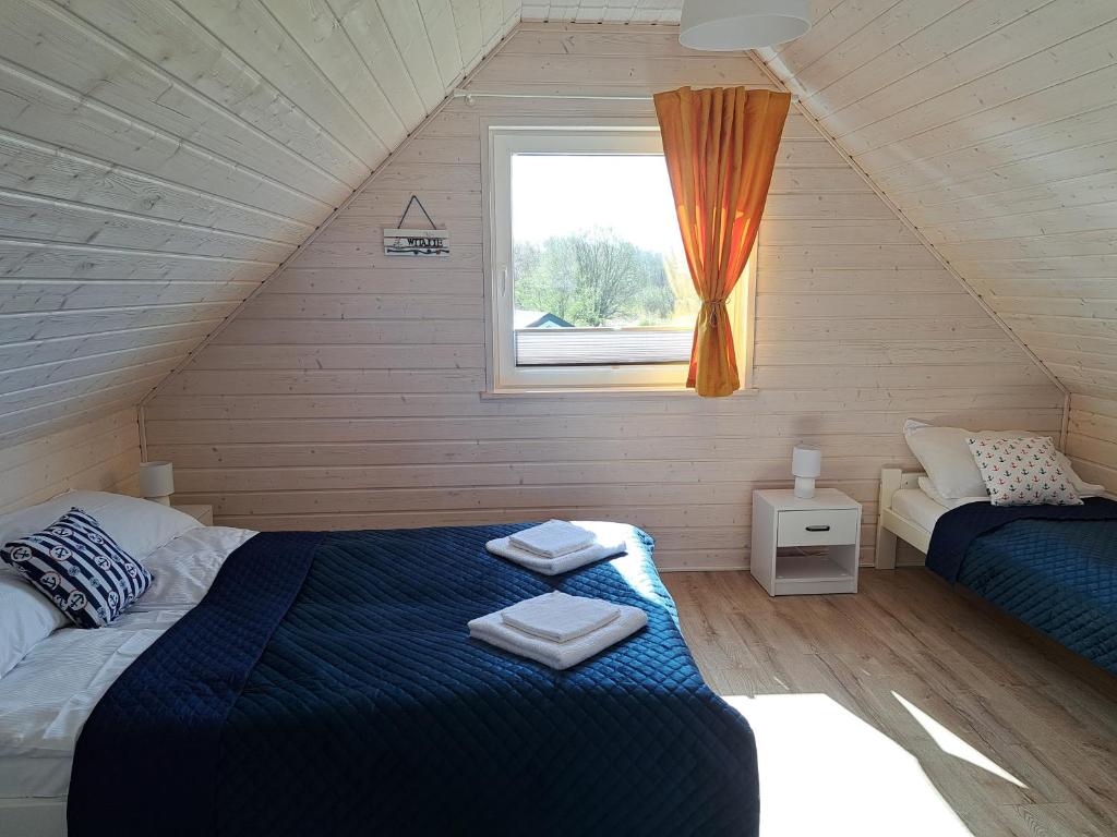 a bedroom with two beds and a window at Błękitne Zamorze i Domki Premium Niechorze in Niechorze