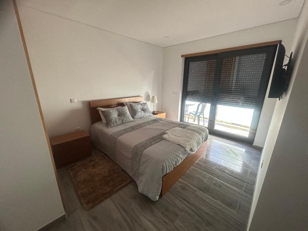 een slaapkamer met een bed en een groot raam bij Casa Gidelos in Geres