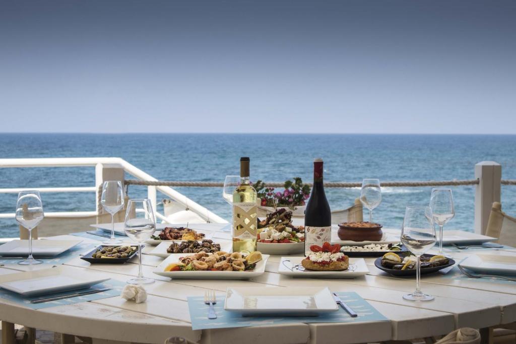 a table with wine glasses and food on a boat at Glaros Beach Hotel in Hersonissos