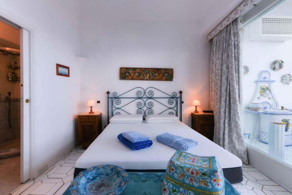 una camera da letto con un letto con cuscini blu di Casa Franca appartamento vista mare a Capri