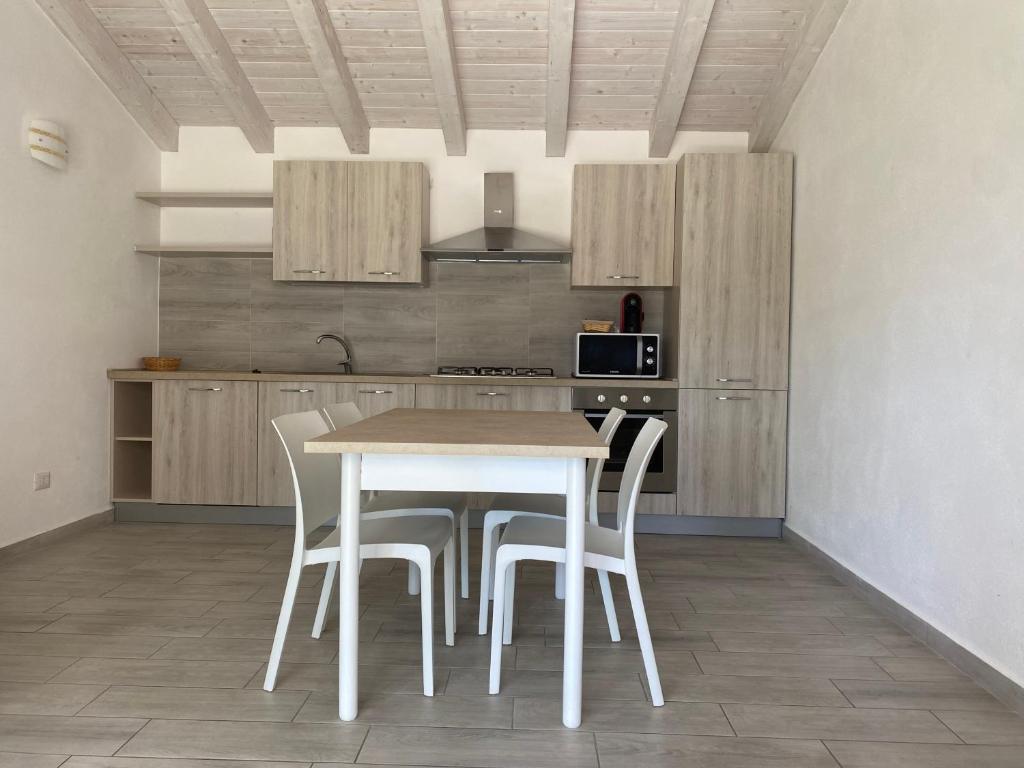 - une cuisine avec une table et des chaises dans la chambre dans l'établissement Villetta 6 La Caletta, à La Caletta