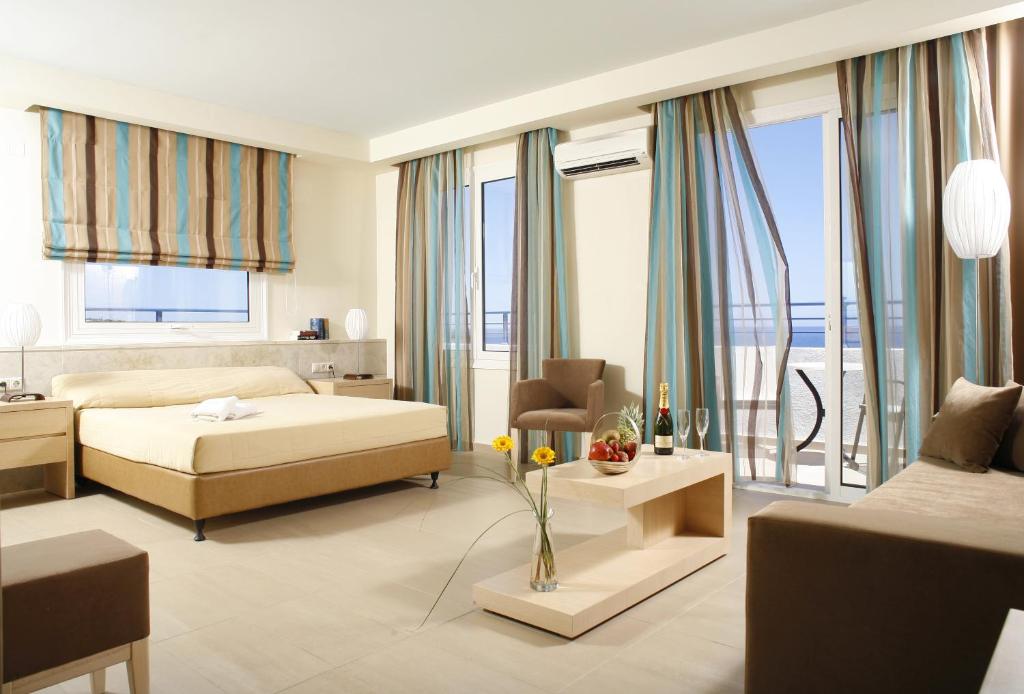a bedroom with a bed and a living room at Glaros Beach Hotel in Hersonissos