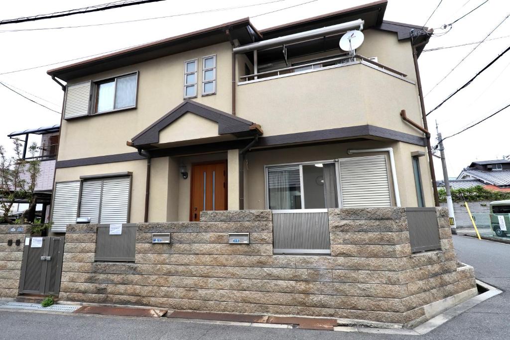 a house with a staircase in front of it at Guest House Kubo Homes Shotenshita in Osaka