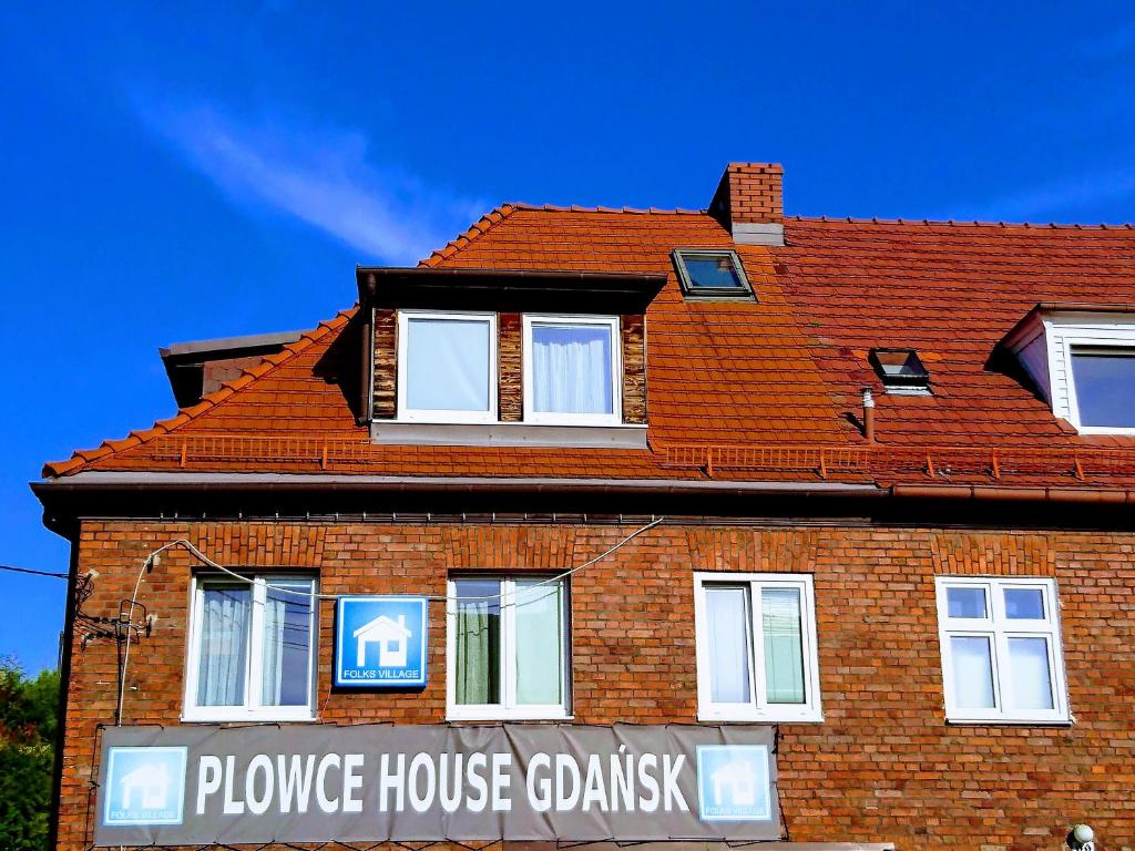 dom z czerwonej cegły z napisem w obiekcie Folks Village Plowce House w Gdańsku