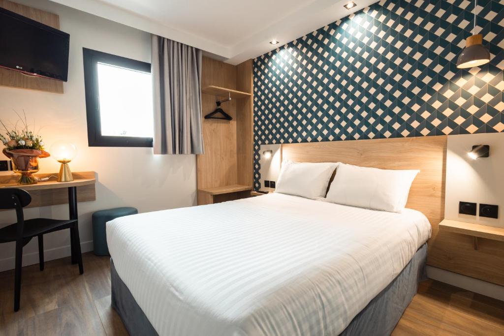 a hotel room with a bed and a desk at KYRIAD DIRECT ORLEANS NORD - Cap Saran in Saran