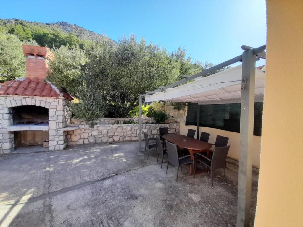a patio with a table and a brick oven at Apartments Dalamar in Babino Polje