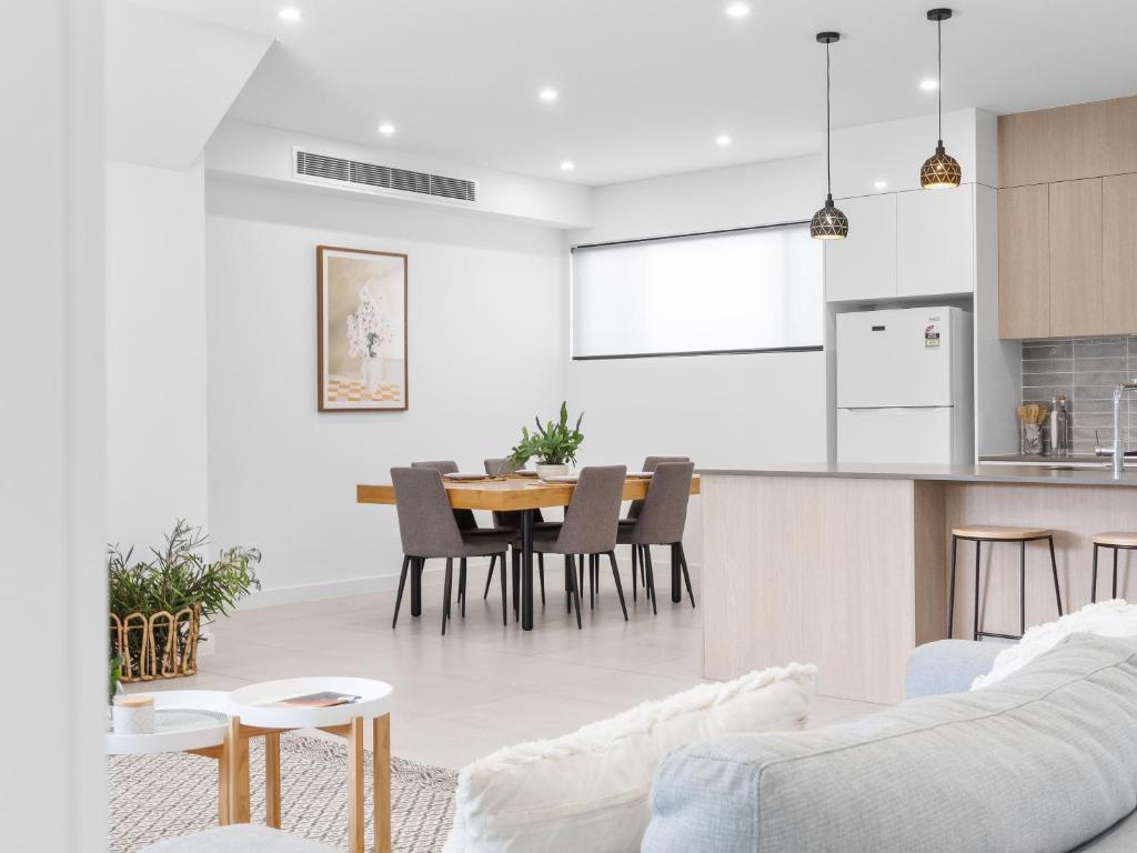 a living room and kitchen with a table and chairs at Palmera on the south coast in Ulladulla
