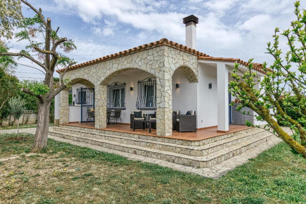 a white house with a patio and trees at Casa Elena in Sant Pere Pescador